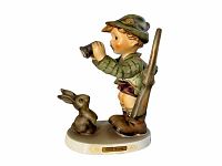 Front-angle view of Hummel Good Hunting #307 figurine showing boy with binoculars, rifle, and rabbit on white base.