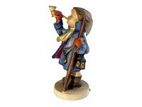 Side view of Hummel figurine showing child blowing horn, holding lantern and staff