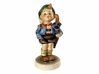 Front view of the Hummel figurine showing a boy with umbrella and bread, on a round base