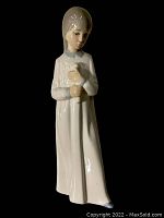 Front view of the Nao Lladro porcelain figurine of a girl holding a candle, glossy finish, no visible damage.