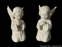 Front view of pair of Sacraft Hummel angel figurines on black background showing detailed sculpting and glossy finish
