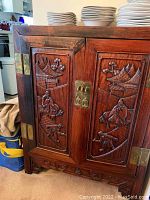 Front view showing carved double doors with brass latch