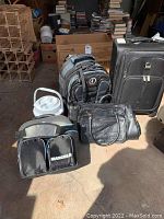 Photo showing entire lot including Maxcold cooler bag, Tamarac backpack, Samsonite luggage, black carry-on bag and white drink cooler.
