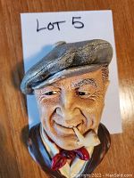 Close-up photo of the Bosson chalkware head figurine showing detailed features, cap, pipe, and scarf.