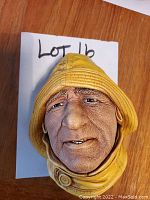 Close-up photo of Bosson chalkware life boatman head plaque showing detailed facial features, textured yellow rain hat and coat collar.