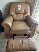 Front view of taupe leather recliner showing seat, backrest and extended footrest