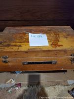 Closed vintage wooden toolbox showing surface wear and metal hinges and handle