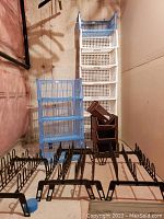 Display of blue and white plastic stacking bins with brown planter boxes stacked between; black metal shoe racks lined up in front.