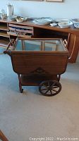 Solid wood vintage tea cart with removable glass top serving tray and large spoked wooden wheels visible
