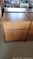 Front view of the teak wood cupboard showing two drawers with recessed handles and light surface wear.