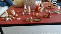 Wide view of various miniatures arranged on a table including animals, plates, and tea set.
