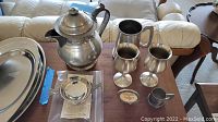 Pewter assortment including teapot, large tray, cups and pitchers