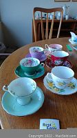 Five assorted bone china teacups and saucers displayed on table