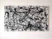 Full straight-on view of stretched canvas showing black enamel splatter over white ground
