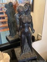 Front view showing intimate pose of the nude male and female figures with detailed polished female figure and textured male figure on felt-covered base.