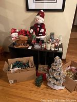 Full lot overview showing Santa figurines, wooden Nativity, boxes of lights and small Christmas tree on the floor.