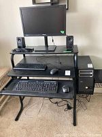 Full view of computer setup displaying Bento CPU tower, Samsung monitor, Logitech keyboard with mouse and speakers, Acer keyboard with mouse.