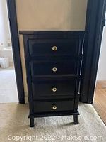 Front view of the tall black cabinet showing all four drawers closed
