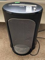 Front view of the black Fellowes paper shredder showing the full unit with removable metal basket and power cord.