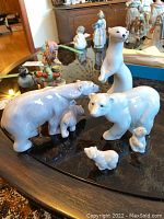 Overview of all five porcelain animal figurines on a black glass tabletop
