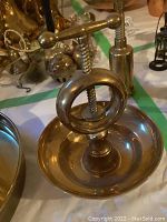 Photo showing the nutcracker, corkscrew, and nutcracker bowl base with screw press handle in solid brass.