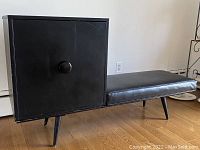 Front view of black cube cabinet and upholstered bench cushion
