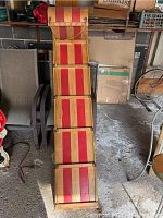 Full length view of the Fury vintage toboggan showing the alternating red and natural wood slats and the braided rope handles.