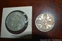 Obverse and reverse of 1946 Half Crown Coin in holder and 1915 One Florin Coin on wooden surface.