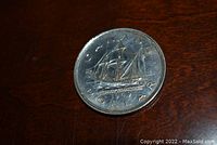 Front of 1949 Canadian silver dollar showing Bluenose schooner and inscriptions.