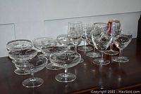 Lot of 14 Cornflower crystal stemware including coupe glasses and wine glasses with etched floral and leaf patterns.