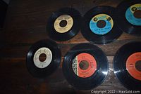 Photo showing six 45 RPM vinyl records with visible MGM and Red Bird labels.