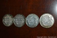 Four Canadian 50 cent coins laid out in a row, showing reverse side with detailed coat of arms and crown design, dated 1937, 1938, 1939, and 1940.