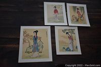 Four framed Chinese rice paper prints laid out on floor, depicting traditional female figures in colorful robes and natural backgrounds.
