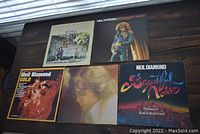 Five Neil Diamond vinyl albums displayed including Stones, Hot August Night, Gold, Beautiful Noise, and a portrait cover album.