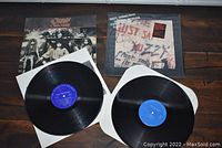 Two opened vinyl record sleeves with exposed records, displaying Ozzy Osbourne's 'The Ultimate Sin' and 'Just Say Ozzy' albums.