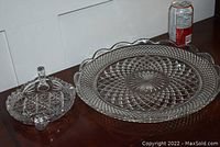 Two glassware platers on a table with a soda can for scale.
