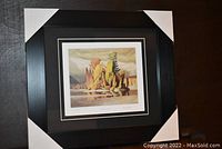 Framed print with protective corner covers, shown angled to view frame details.