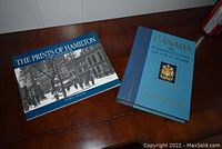 Two hardcover books, one 'The Prints of Hamilton' with black and white photo cover and one 'Canada The Foundations of Its Future' with blue cover and crest.