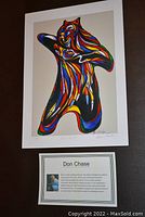 Full view of the unframed colorful artistic print "Bear Spirit" by Don Chase with artist profile card beneath it on a table surface.