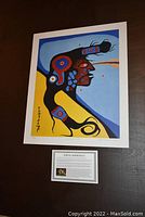 Photo of the unframed 24x20 inch print "Spiritual Self" by Norval Morrisseau laid flat on a surface, showing the colorful artwork.