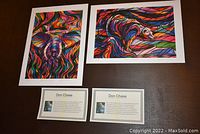 Two colorful abstract animal-themed prints "Spiritual Elephant" and "Salmon Hunter" by Don Chase along with two artist profile cards.