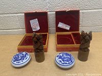 Two vintage Asian stamp sets showing carved seal stamps and ceramic ink pads in red and gold fabric-lined boxes.