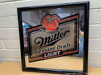 Frontal view of the square framed Miller Genuine Draft Light beer bar mirror showing the reflective surface and printed logo.