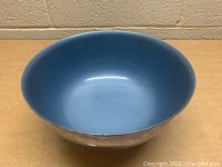 Front angled view of the vintage silver plated bowl showing the blue interior and smooth curved shape.