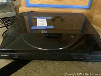 Front view of Sony turntable with closed dust cover showing Sony logo and control buttons on front panel.