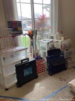 Overview of storage drawers, rolling crates, and craft supplies along a windowed wall