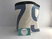 Front view of the hand-made tote bag showing aqua number print and black trim top.