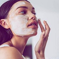 Model applying facial mask
