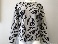 Front view of Seasalt Cornwall sweater featuring black seaweed pattern on beige background.