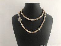 Front view of the hand crafted necklace displayed on a black bust, showcasing the alternating silver and gold links and the heart clasp.